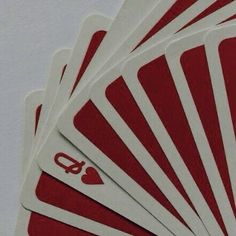 six red and white playing cards with the number four on each card in front of them