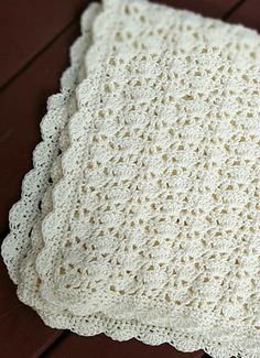 a white crocheted blanket sitting on top of a wooden floor