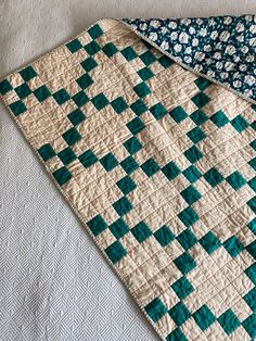 two quilts laying next to each other on top of a white bed coverlet