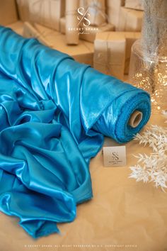 a blue cloth is laying on the table next to some christmas decorations and presents in glass vases