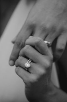 two people holding hands with rings on their fingers