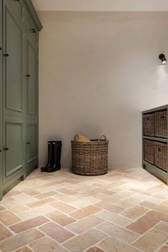 an empty room with green cabinets and two baskets on the floor next to each other