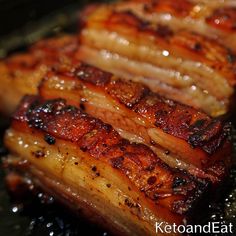 three pieces of cooked meat sitting on top of a pan covered in oil and seasoning