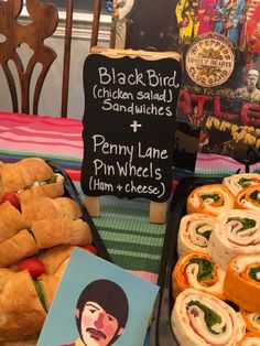 a table topped with lots of sandwiches and rolls