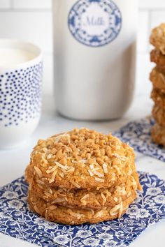 three oatmeal cookies stacked on top of each other next to a glass of milk