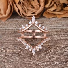 a rose gold wedding ring set with two pear shaped diamonds on the top and side