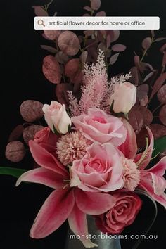 a vase filled with pink flowers and greenery