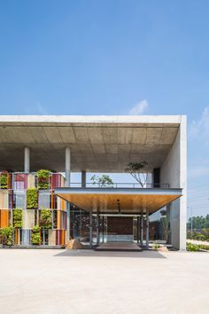 the building has many different colored panels on it's sides and is surrounded by concrete pillars