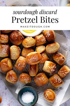 some pretzel bites sitting on top of a table next to a bowl of sea salt