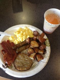 a white plate topped with breakfast foods next to a cup of tea