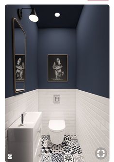 a white toilet sitting next to a sink in a bathroom under two pictures on the wall