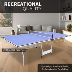 a blue ping pong table sitting on top of a hard wood floor next to a couch