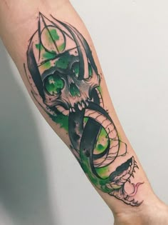 a tattoo design on the arm of a person with green eyes and a demon's head