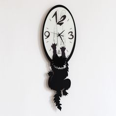 a black and white clock hanging from the side of a wall with cats on it