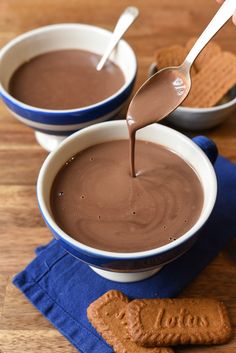 two bowls filled with chocolate and peanut butter on top of a blue napkin next to crackers