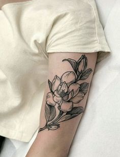 a woman's arm with a flower tattoo on the left side of her arm