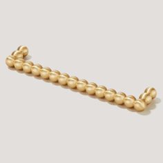 a gold beaded bracelet on a white background with space for the word'love '