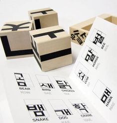 four wooden blocks with chinese characters on them sitting next to some sort of stamping