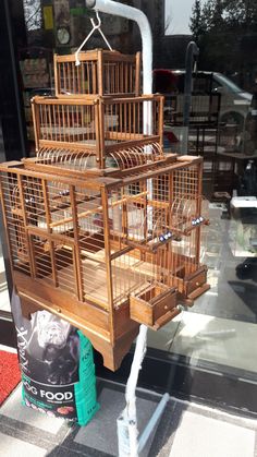 a wooden bird cage sitting on the side of a building