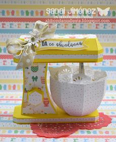 a yellow and white stand mixer sitting on top of a table next to a box