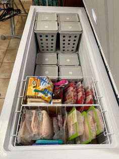 an organized kitchen drawer filled with food and storage bins on the side of a refrigerator