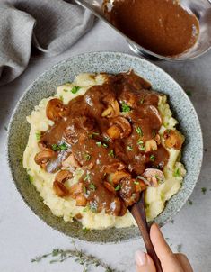 a bowl filled with mashed potatoes covered in mushroom gravy