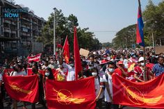 a large group of people holding red and yellow flags