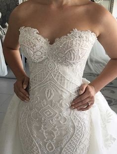 a woman in a wedding dress is posing for the camera