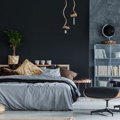 a bedroom with black walls and furniture in the corner, along with a large bed