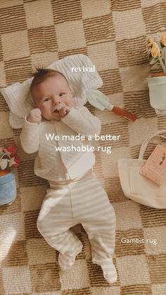 a baby laying on the floor with food in his mouth and other items around him