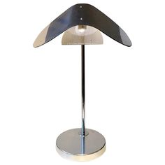 a lamp that is sitting on top of a metal stand with a white light in the middle