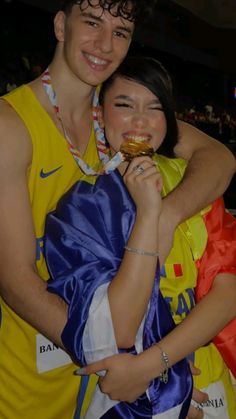 a man and woman are posing for a photo while holding doughnuts in their hands