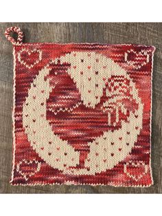 a red and white rug sitting on top of a wooden floor next to a piece of wood