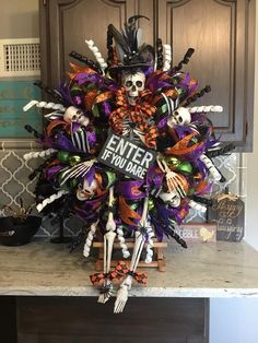 a halloween wreath on top of a kitchen counter with skeleton decorations and candy in it