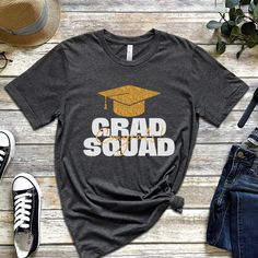 Graduation Squad Shirt, Graduate Shirt, Squad Shirt, Grad Squad Shirt, Proud Family Of The Graduate, Congrats Shirt, Graduation Shirt 2023! Everyone needs the perfect t-shirt to complement an everyday, laid-back look. The ideal top for so many occasions, this lightweight cotton tee will keep you comfy and looking smart. * 100% combed and ring-spun cotton (Heather colors contain polyester) * Fabric weight: 4.2 oz/yd² (142 g/m²) * Pre-shrunk fabric * Side-seamed construction * Shoulder-to-shoulder Grad Squad Shirt Ideas, Casual Short Sleeve T-shirt For Graduation Gift, Casual Crew Neck Top For Graduation Gift, Casual Cotton T-shirt For Graduation, Casual Tops For College Graduation, School Spirit Tops For College Graduation, Graduation School Spirit Short Sleeve Tops, Casual Graduation Shirt With Text Print, Short Sleeve Tops With Letter Print For Graduation Gift