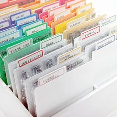 there are many file folders with name tags in them on the shelf next to each other