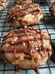 cookies covered in chocolate and caramel drizzled with icing on a cooling rack