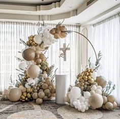 a christmas tree decorated with gold and white balloons