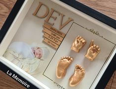 a baby's hand and foot casts in a shadow box with the words dev on it