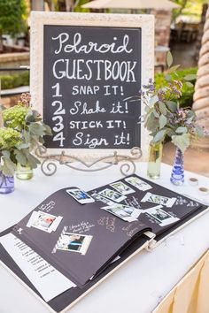 a sign that is on top of a table with flowers in vases next to it