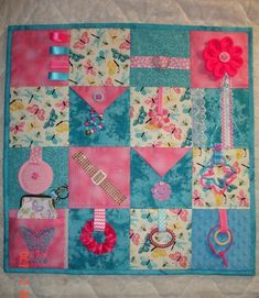 a quilted wall hanging with various items on it