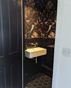 a bathroom with a sink, mirror and tiled walls in black and white colors on the wall