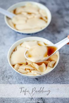 two bowls filled with food sitting on top of a counter next to a spoon in them