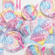 tie - dyed paper plates and napkins with pink forks and spoons on them