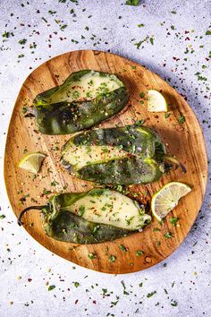 stuffed jalapenos on a wooden platter with limes and seasoning