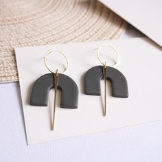 two pairs of earrings on top of a piece of paper