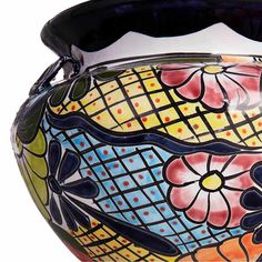 a colorful vase with flowers painted on the outside and inside it's lid is shown