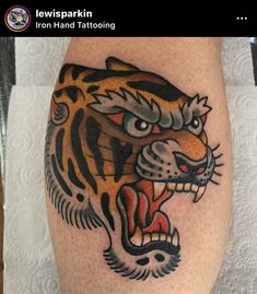 a tiger tattoo on the leg of a person