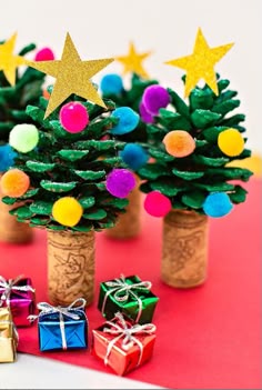 small christmas trees made out of wine corks with colorful balls and pom - poms