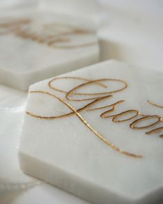 three white soaps with gold lettering on them